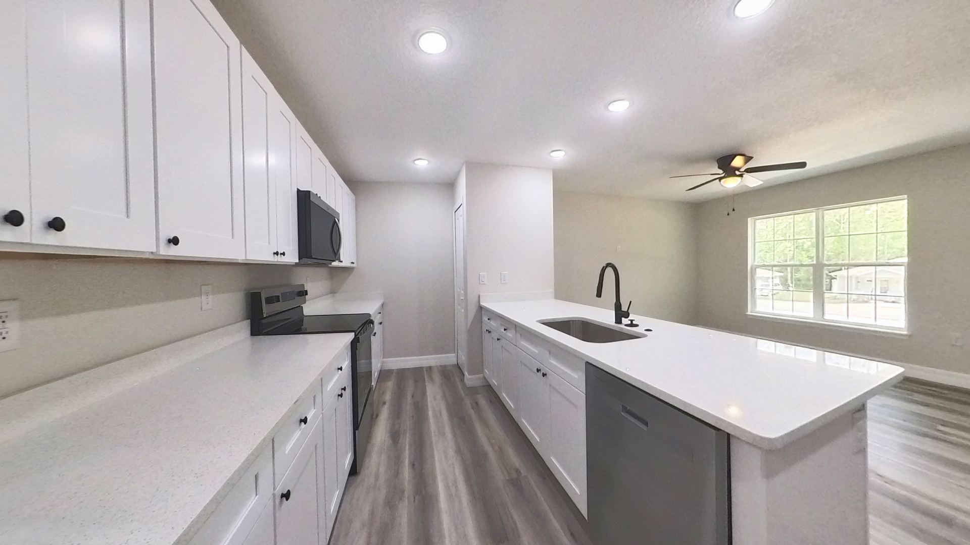 Kitchen with white shaker cabinets and stone counters
